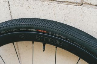 A black gravel tyre against a stone wall