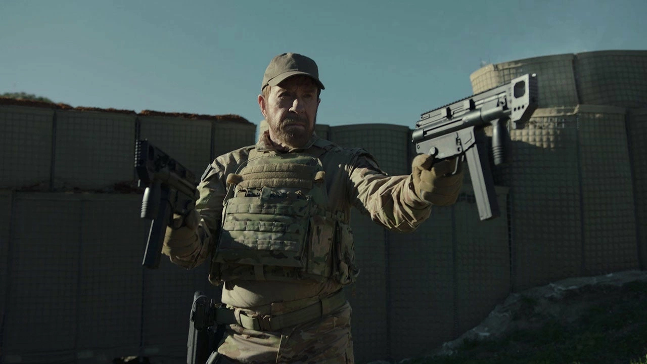 A still from the film Agent Recon of a character dressed as a soldier and holding a gun.