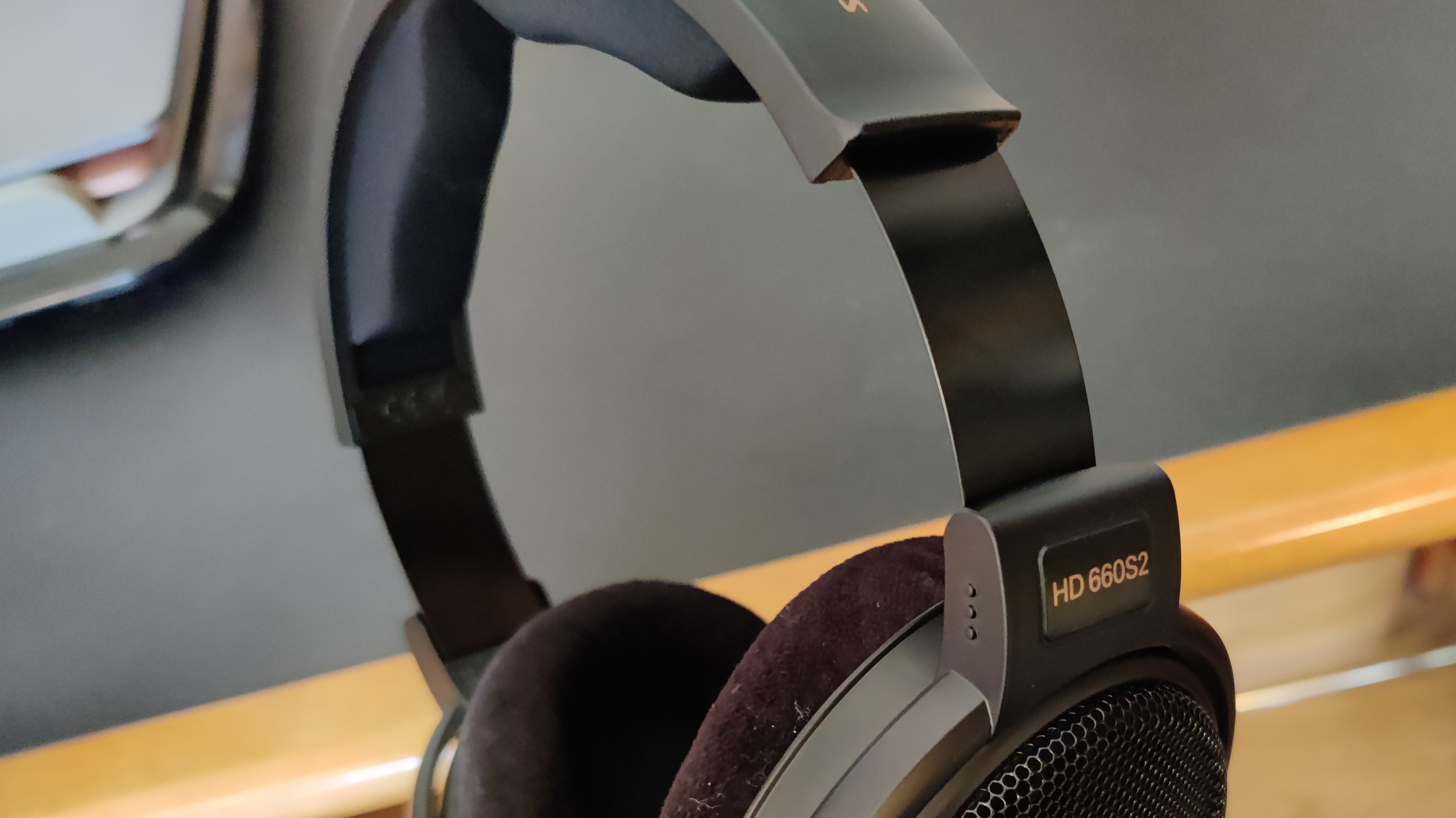 A close-up of the Sennheiser HD-660S2 headphones against a wooden surface.