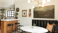 kitchen with a breakfast nook featuring a white marble table, a black bench, and paintings on the walls