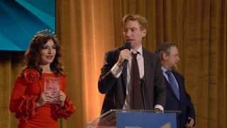 Domhnall Gleeson, Sabrina Impacciatore, and Tim key standing on stage in The Paper.