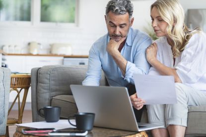Couple concerned looking at laptop screen