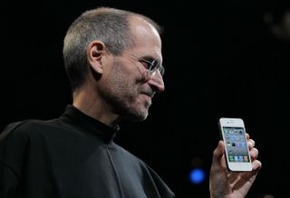 Steve Jobs holding an iPhone.