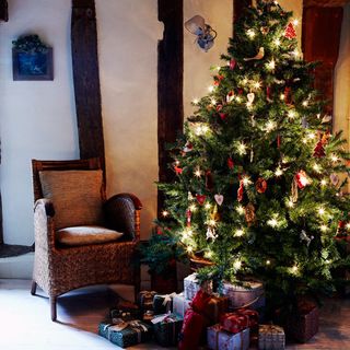 room with christmas tree and armchair and gifts