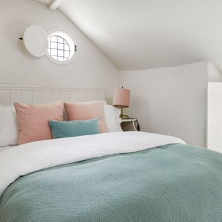 bedroom with round window and solid shutter