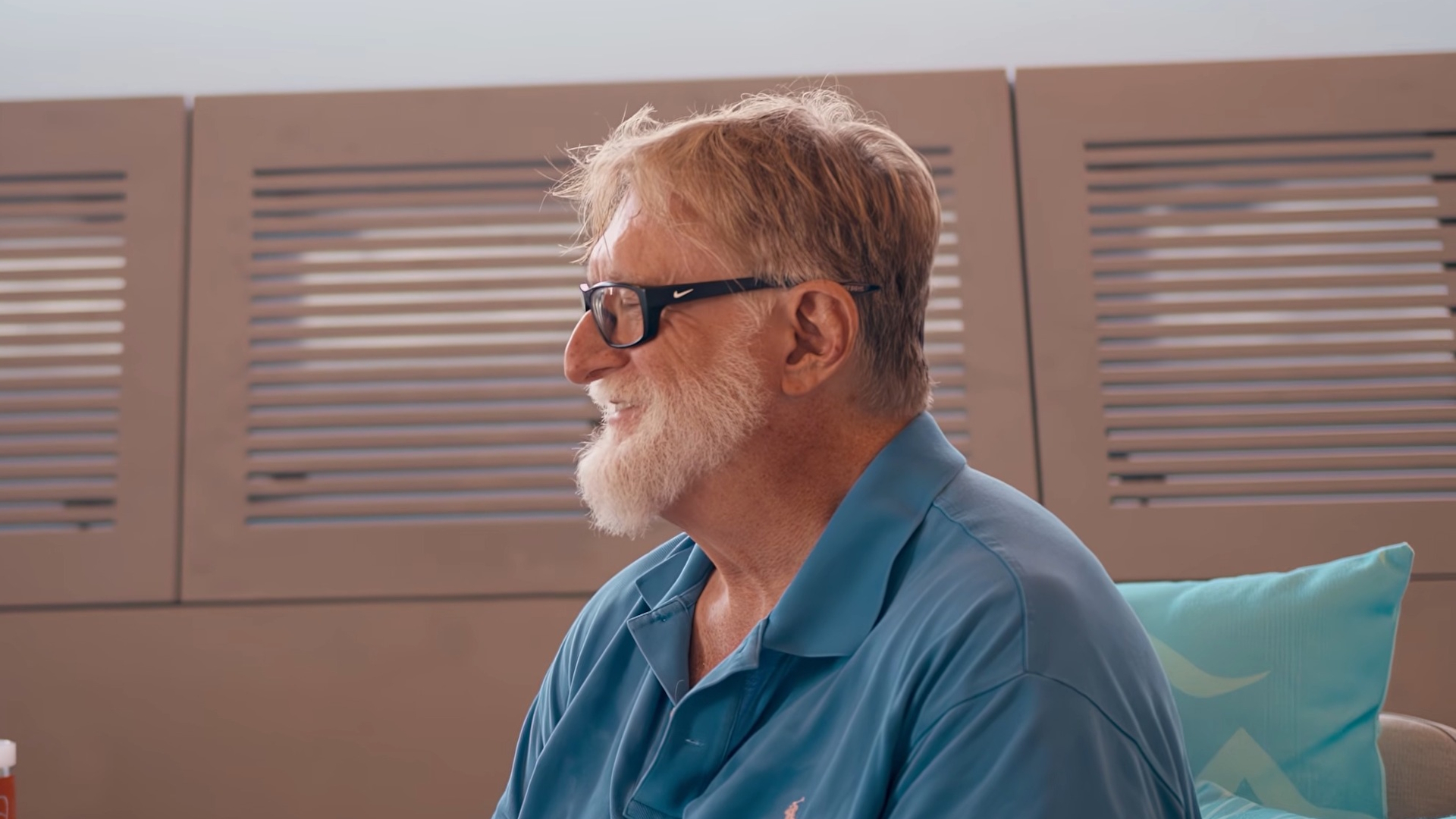 Gabe Newell in blue shirt and black glasses