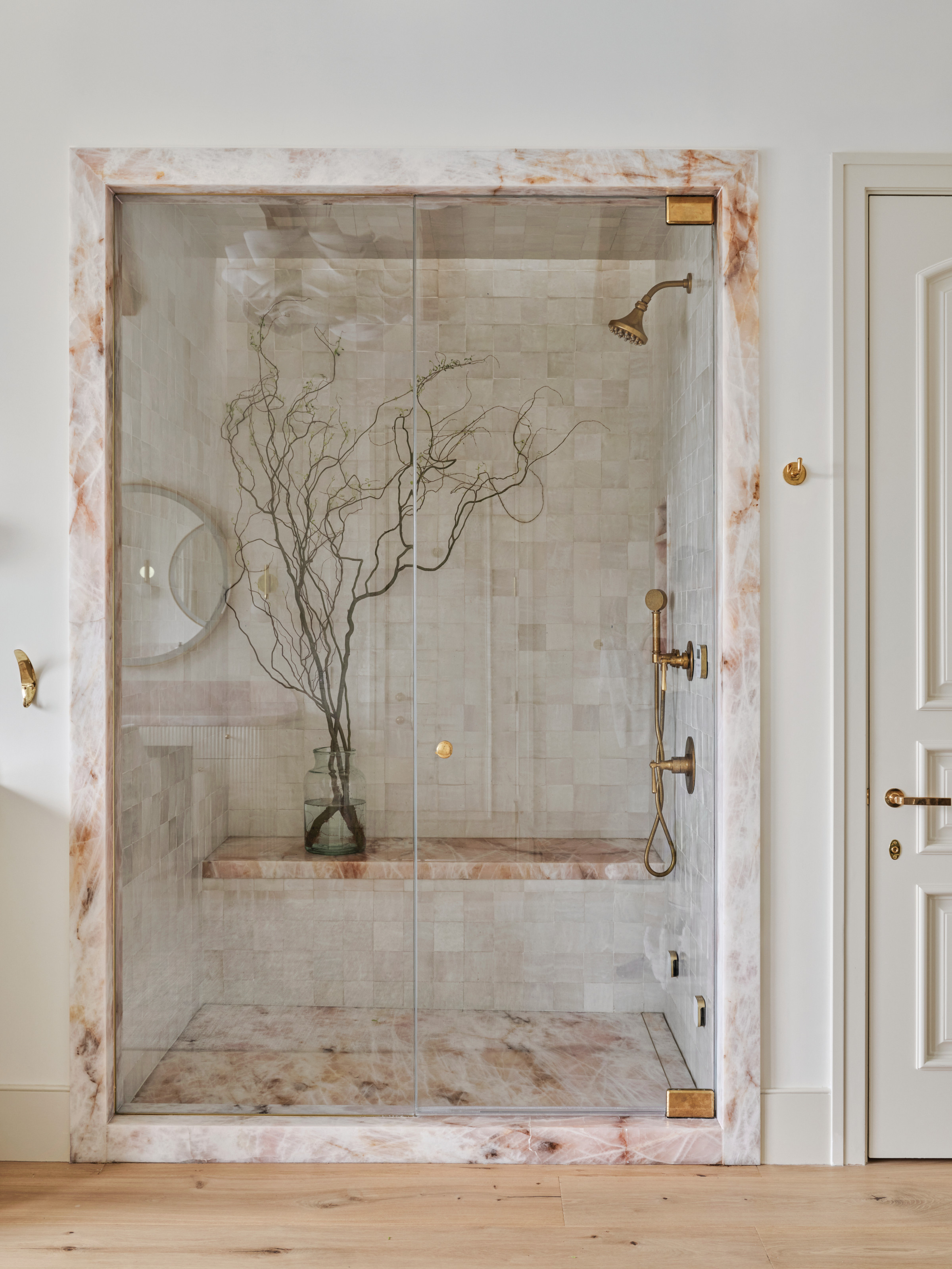 Shower area of bathroom with pink stone surround and floor