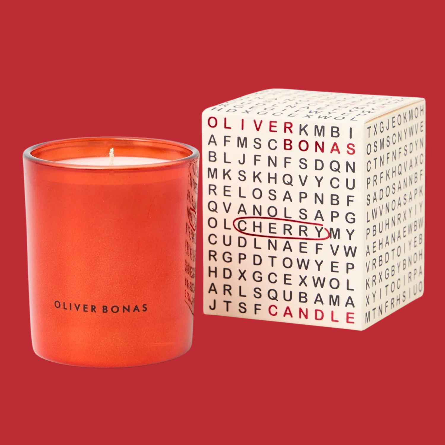 A red glass candle by a word search themed box