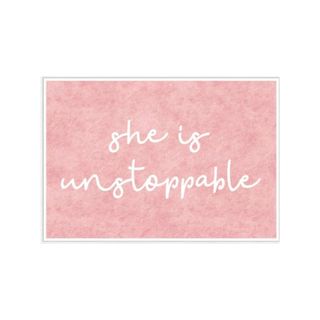 A pink wall print that says 'she is unstoppable'