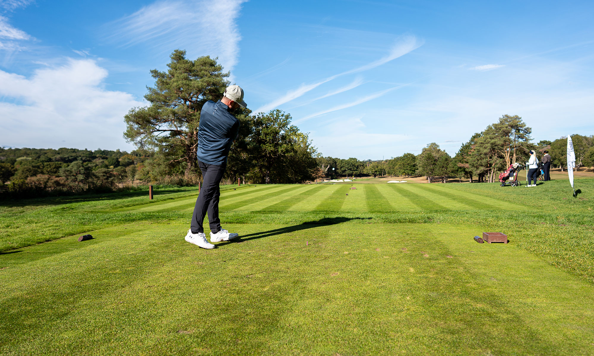 Baz Plummer just past impact with driver as the ball travels forwards towards the fairway