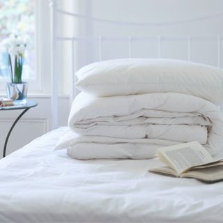 white duvet stacked on top of each other on bed