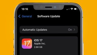 Un iPhone sobre fondo amarillo mostrando la página de instalación de iOS 17