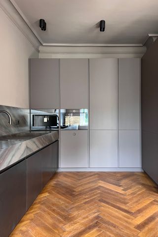 A kitchen with dark wooden flooring