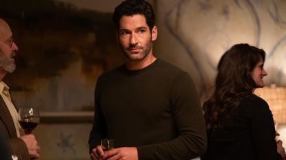 Tom Ellis as Oliver, standing among guests at a party, in &#039;Tell Me Lies&#039;