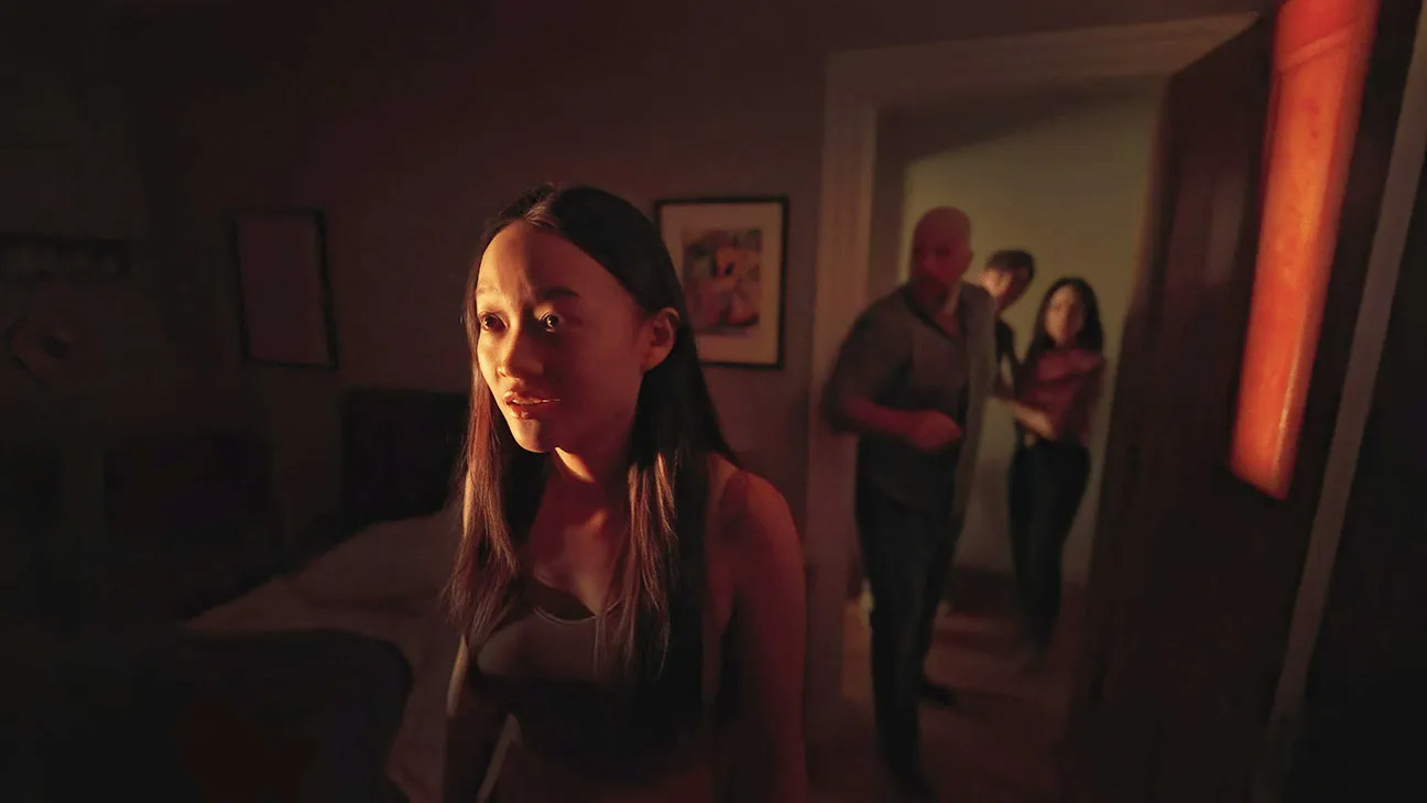 Callina Liang as Chloe Payne in Presence, with the rest of the family behind her out of focus.