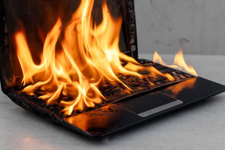A laptop on fire with flames covering the keyboard