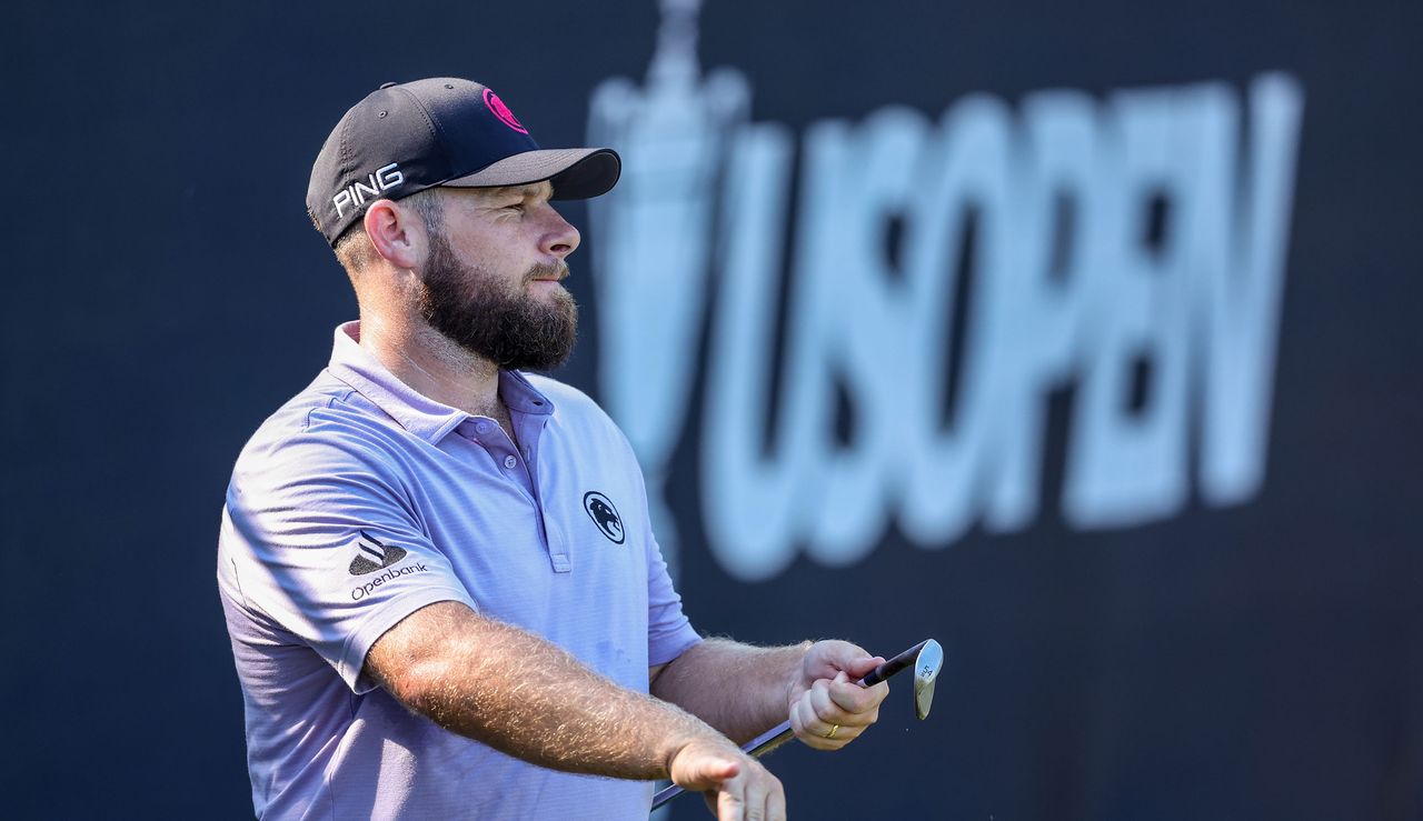 Tyrrell Hatton wipes the face of his wedge with his hand