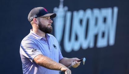 Tyrrell Hatton wipes the face of his wedge with his hand