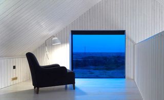 white attic room with black armchair