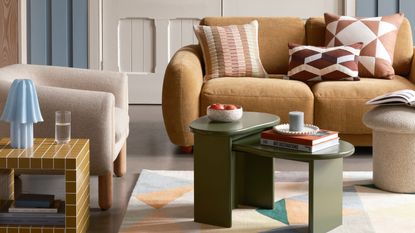 living room with fabric armchair with timber legs, yellow tiled side table with blue lamp, green nesting coffee table on patterned rug in front of yellow velvet sofa with brown and white cushions