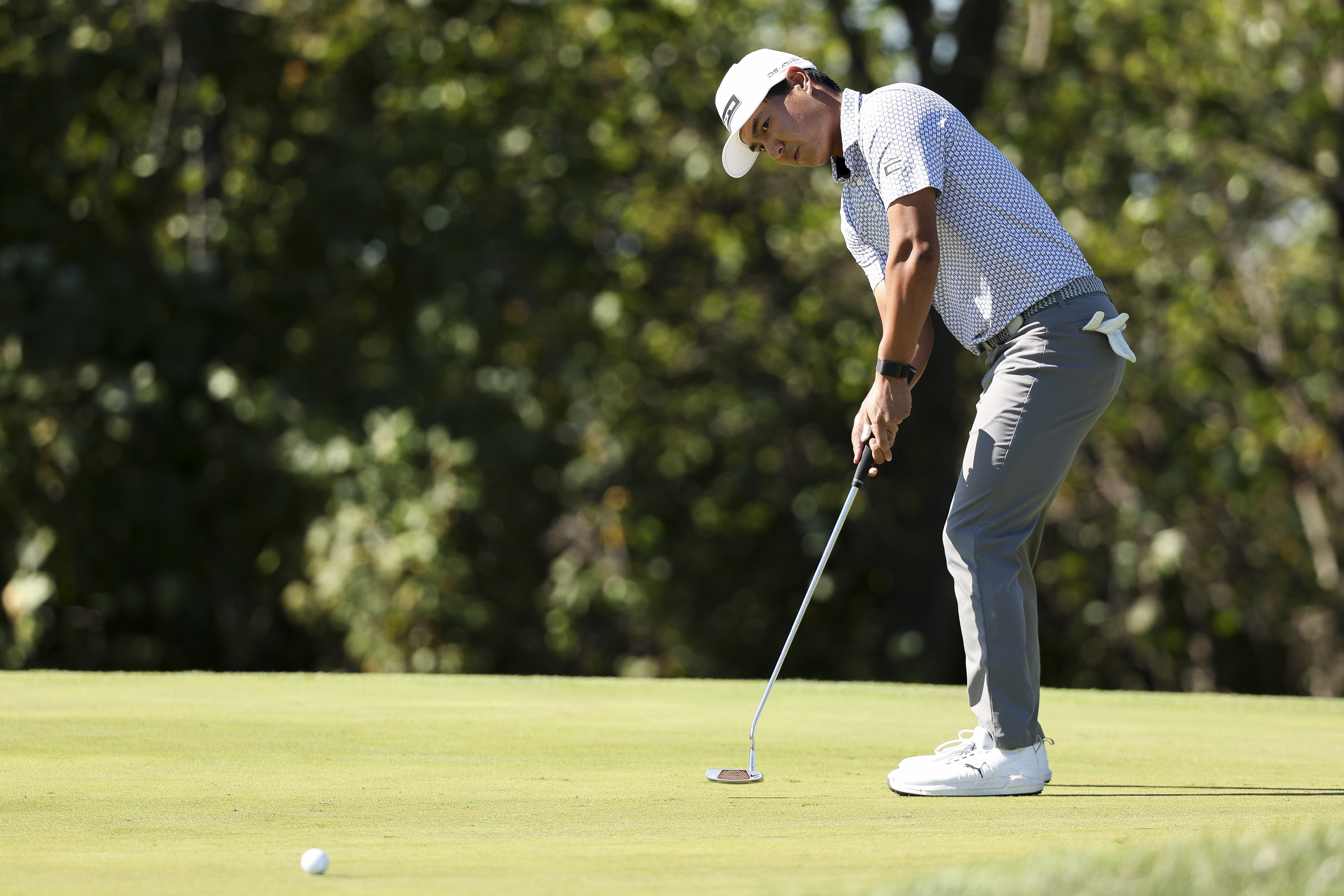 Justin Suh hits a putt