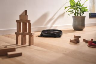 Miele vacuum cleaner on a wooden floor with kids wooden building blocks