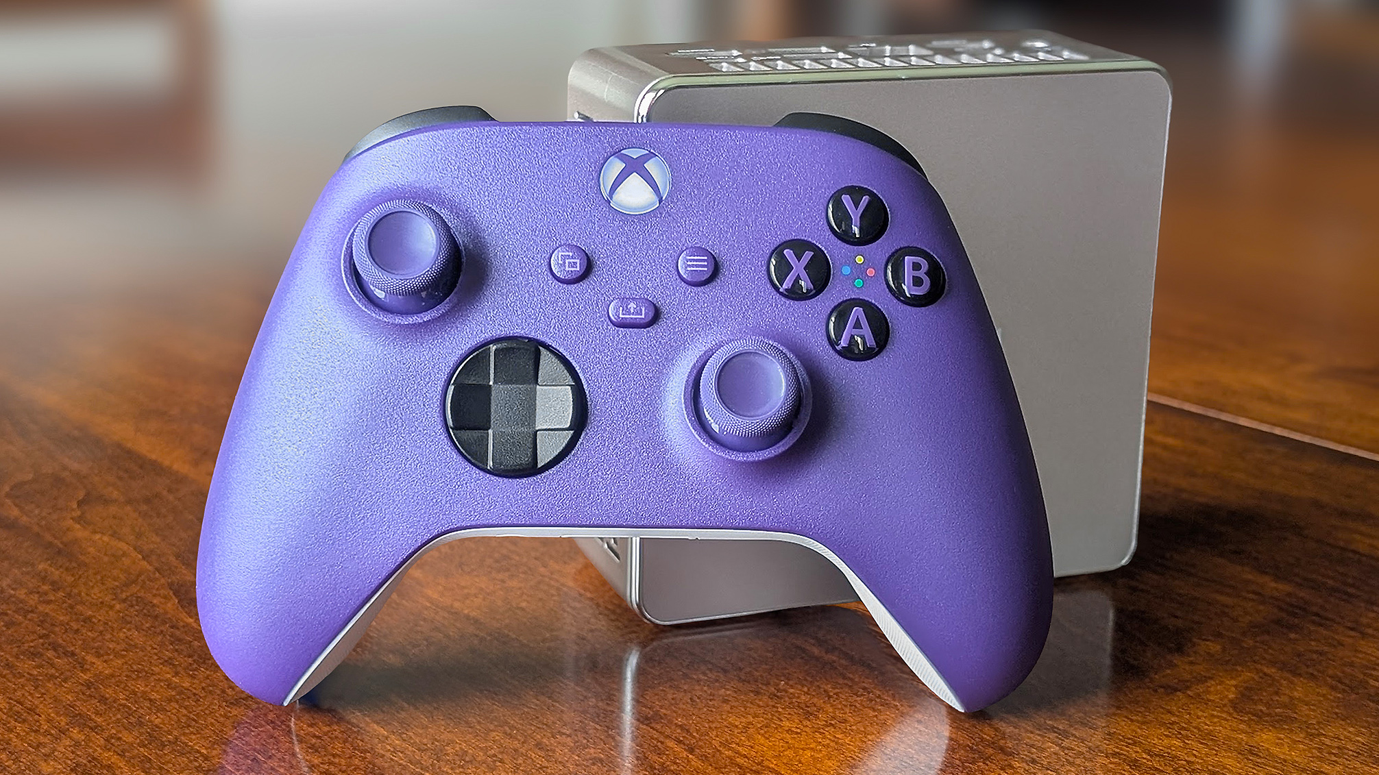 A purple Xbox Controller in front of a Geekom mini PC.