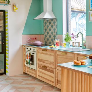 Wooden kitchen units in a green and pink kitchen
