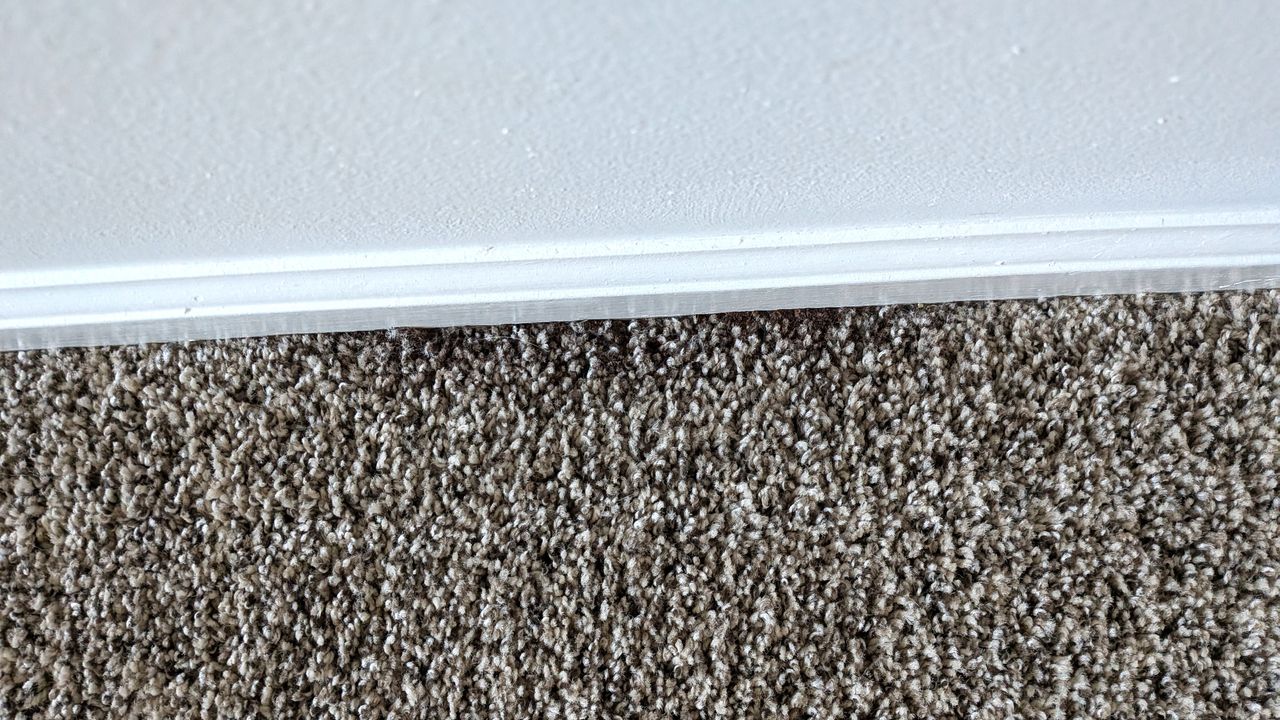 Coffee grounds on edge of carpet after one pass with Shark PowerDetect Speed vacuum cleaner on low power