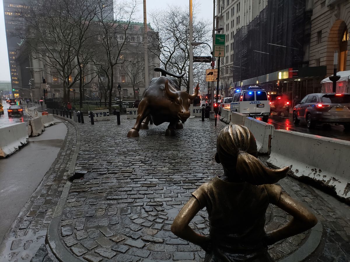 The Charging Bull statue in the Financial District of New York City on a dreary, sleet-filled day