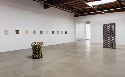 Large gallery space with concrete floors and folded t-shirts and shirts on the wall