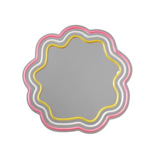 A flower shaped mirror with pink and yellow neon lights