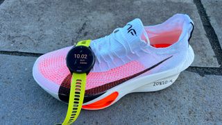 Nike Alphafly 3 with Garmin Forerunner 965 draped across toe box. Screen reads 10.02 (distance in km), 35:27 (minutes and seconds) and 3.32/km (pace)