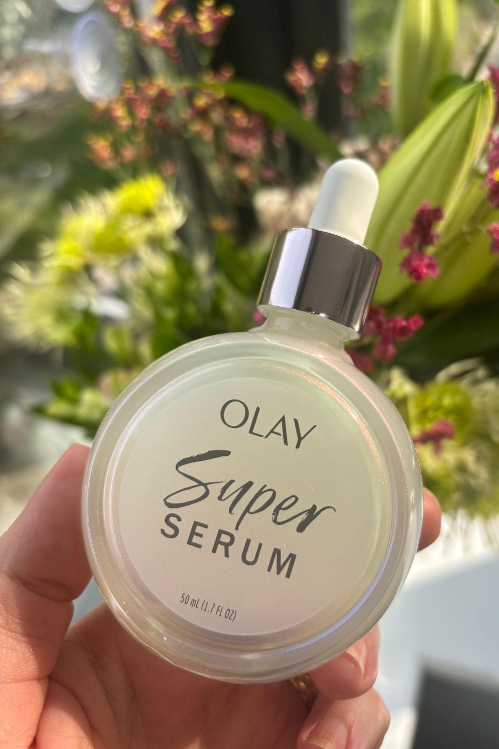 a hand holding olay super serum