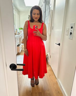 Mindy Kaling takes a mirror selfie while wearing a red dress and a matching phone case fromReplica Store.