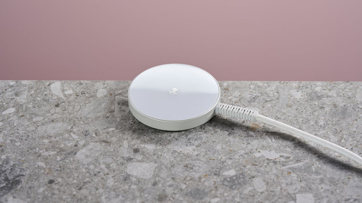 ESR Qi2 Mini Wireless Charger sits on a light grey stone-effect surface against a pink background.