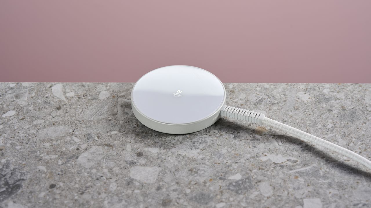 ESR Qi2 Mini Wireless Charger sits on a light gray stone-effect surface against a pink background.