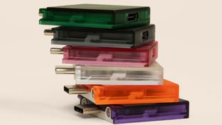 Translucent, colorful, Framework Laptop 13 expansion cards in green, black, pink, white, orange, and purple.