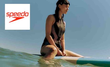 speedo logo in the top left with a woman on surfboard with goggles on her head