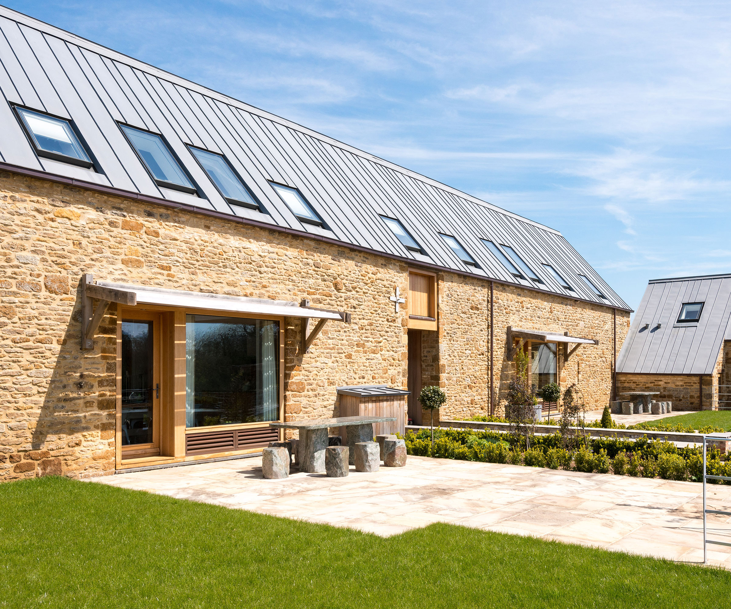 converted barn building with stone walls, zinc roof and conservation-style rooflights