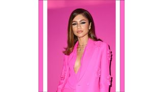 Zendaya wears her hair in a side parting and wears a hot pink suit as she attends the Valentino Womenswear Fall/Winter 2022/2023 show as part of Paris Fashion Week on March 06, 2022 in Paris, France.