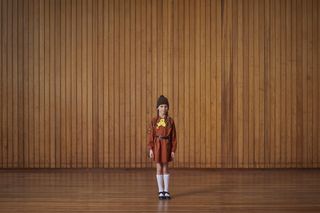 A child standing in a wood panelled room