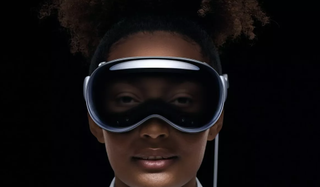 Apple Vision Pro headset worn by a woman whose eyes are shown on the EyeSight screen