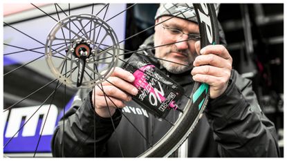 A CanyonSRAM mechanic repairs a tubeless tyre using a Muc-Off product