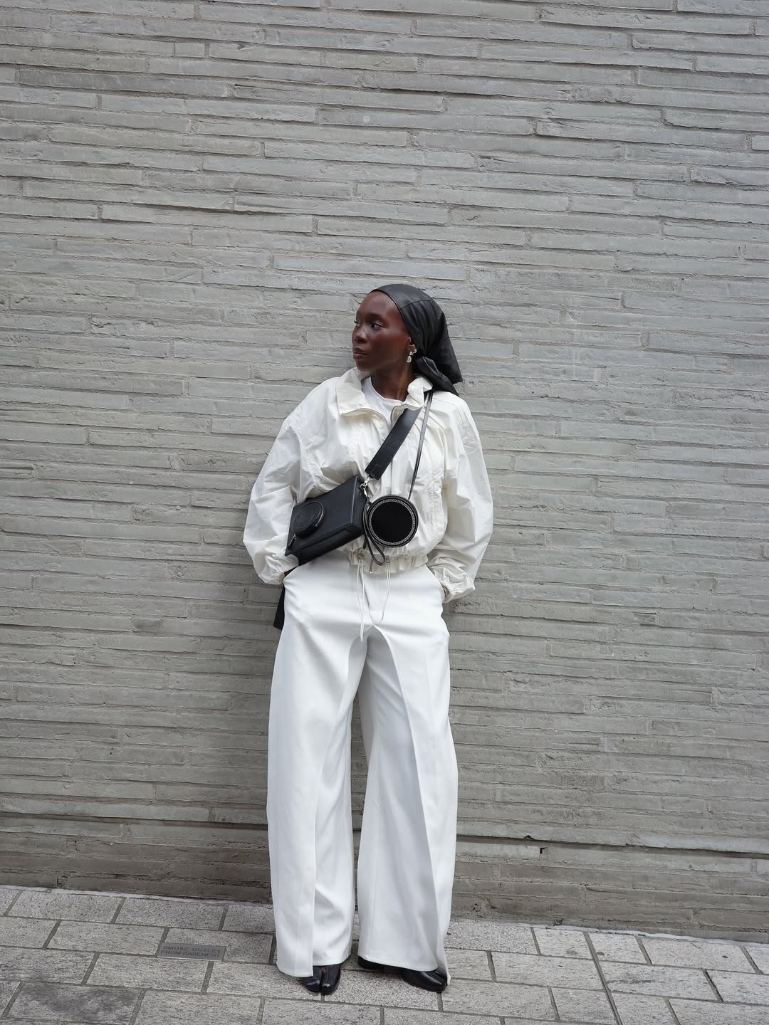 Danielle in a white technical jacket and trousers