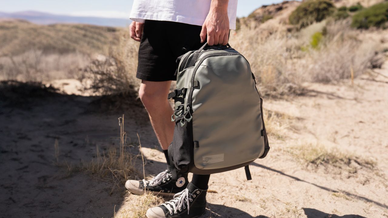 The Wandrd Stratus camera backpack carried by the top grab handle