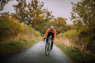 Image shows a rider cycling outdoors in the winter