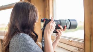 author shooting through a window using the OM-1 Mark II