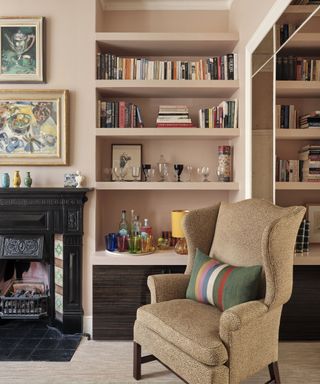Black fireplace, brown armchair, pink shelves