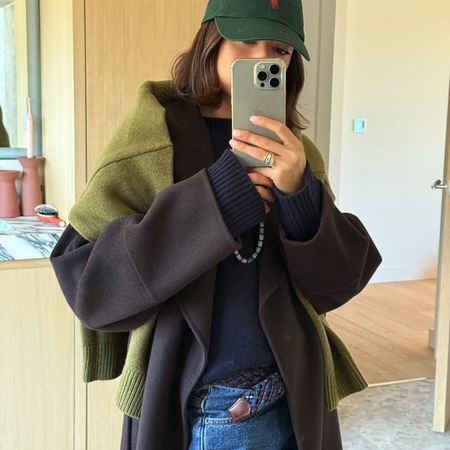 Woman in brown coat and green sweater